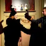 deux jeunes manipulent des marionnettes l un souriant l autr